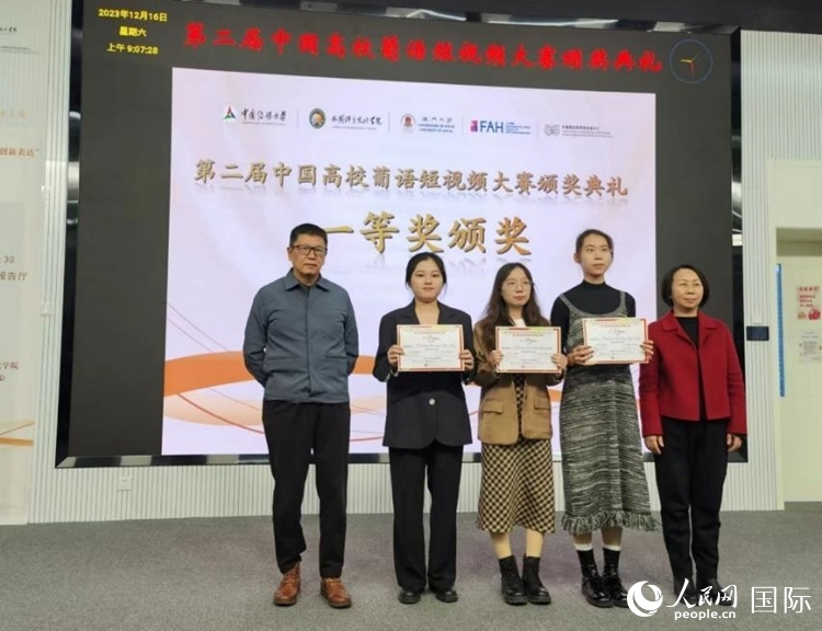 澳門(mén)大學(xué)中葡雙語(yǔ)教學(xué)暨培訓(xùn)中心主任姚京明（左一）和中國(guó)傳媒大學(xué)外國(guó)語(yǔ)言文化學(xué)院院長(zhǎng)文春英（右一）為一等獎(jiǎng)獲得者頒獎(jiǎng)。人民網(wǎng)記者 魯揚(yáng)攝