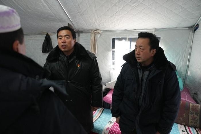 2023年12月22日，積石山縣大河家鎮(zhèn)大河村黨支部書記馬成忠（右二）在帳篷里和受災(zāi)群眾交流。新華社記者 陳斌 攝