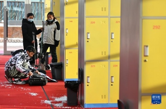 12月21日，游客在滑雪服務(wù)大廳整理滑雪裝備。