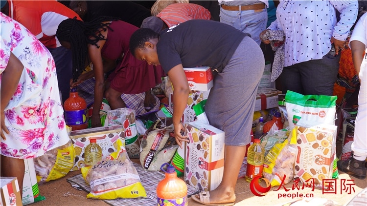 當(dāng)?shù)厣鐓^(qū)家庭領(lǐng)取物資。人民網(wǎng) 張茜攝