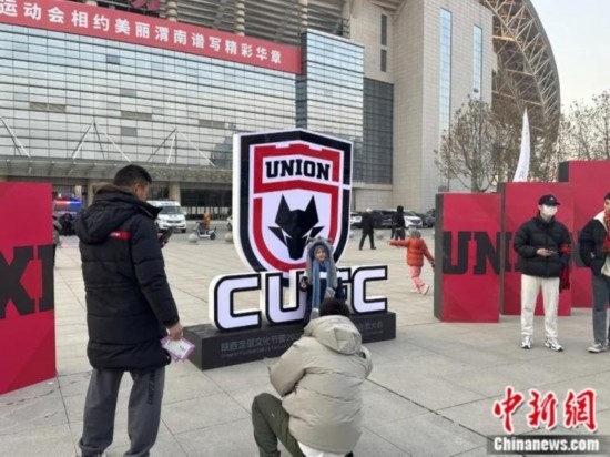 球迷們與隊(duì)徽合影。記者 卞立群 攝