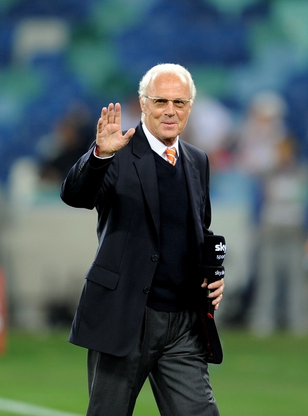 這是2010年7月7日，在南非德班舉行的2010年足球世界杯德國(guó)隊(duì)對(duì)陣西班牙隊(duì)的半決賽前，貝肯鮑爾接受電視臺(tái)采訪時(shí)和友人打招呼。新華社記者 王毓國(guó) 攝