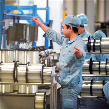 在位于武漢的長(zhǎng)飛光纖光纜股份有限公司光纖生產(chǎn)車間內(nèi)，工作人員對(duì)光纖進(jìn)行檢測(cè)（資料圖片）。肖藝九攝/本刊