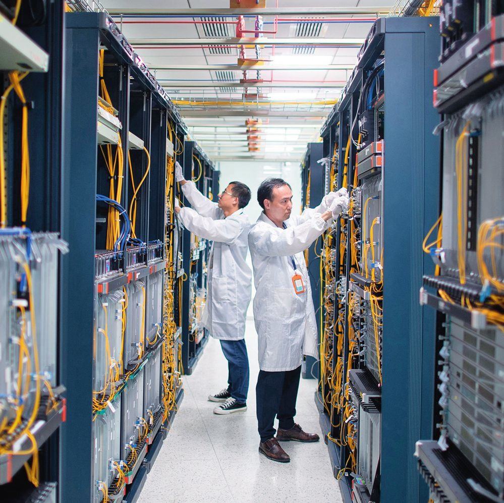 在位于武漢中國(guó)光谷的光電器件研發(fā)制造商——武漢光迅科技股份有限公司生產(chǎn)車間內(nèi)，技術(shù)人員在光模塊生產(chǎn)線作業(yè)（2023年4月11日攝）。程敏攝/本刊