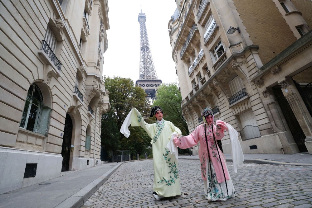 2023年9月13日，江蘇省演藝集團(tuán)昆劇院院長(zhǎng)施夏明（左）和江蘇省演藝集團(tuán)昆劇院國(guó)家一級(jí)演員孔愛(ài)萍在法國(guó)巴黎埃菲爾鐵塔附近參加昆曲快閃。新華社記者 高靜 攝