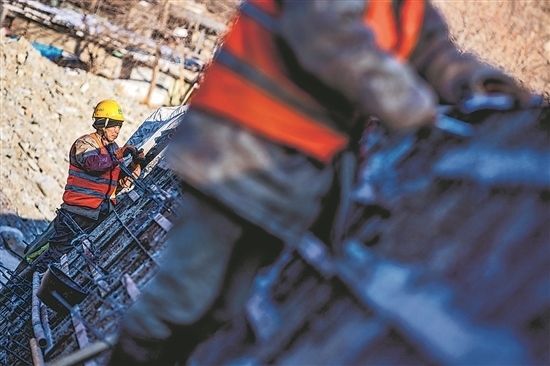 1月3日，房山區(qū)，工人正在雙泉河修筑堤壩。