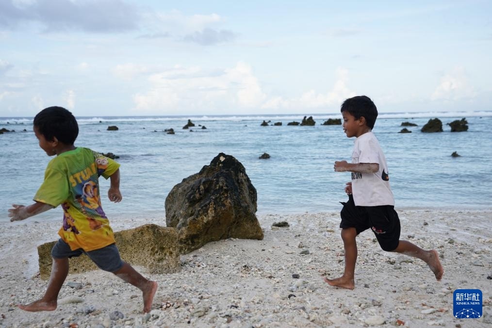 1月20日，兒童在瑙魯海邊嬉戲。新華社記者 王申 攝