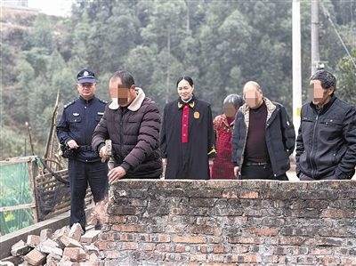  圖③：庭審結束后，在法官的見證下，陳某在院壩邊重新開鑿一條通道。