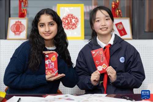 1月28日，美國馬斯卡廷中學(xué)學(xué)生（左）和復(fù)旦大學(xué)第二附屬學(xué)校學(xué)生展示互相送出的寫有寄語祝福的紅包。 新華社記者 王翔 攝