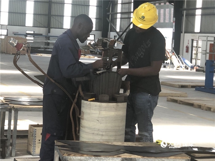 經(jīng)貿(mào)合作區(qū)廠房內(nèi)，當?shù)毓と苏诰o張作業(yè)。人民網(wǎng)記者 黃培昭攝