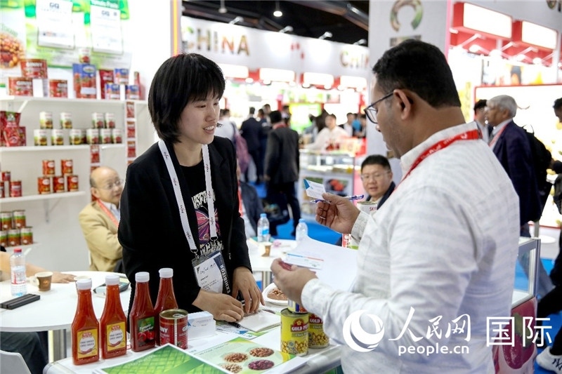 圖為中國(guó)參展企業(yè)代表與采購(gòu)商交流。人民網(wǎng) 塔里克·易卜拉欣攝