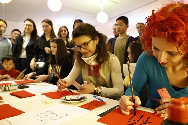 羅馬尼亞觀眾學(xué)習(xí)用毛筆寫“?！弊?。中國文化中心供圖