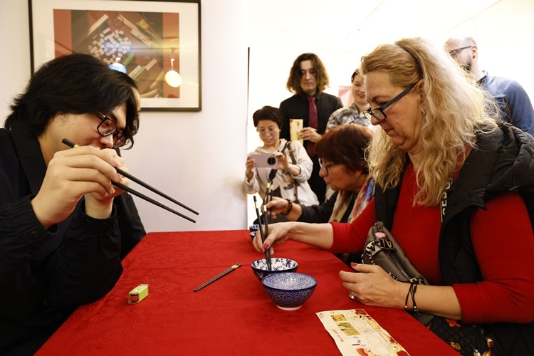 羅馬尼亞觀眾體驗用筷子夾花生。中國文化中心供圖