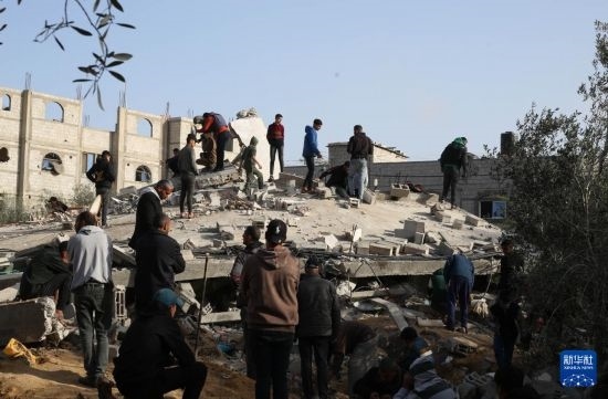  3月3日，在加沙地帶南部城市拉法，人們查看被以軍空襲破壞的建筑。新華社發(fā)（哈立德·奧馬爾攝）
