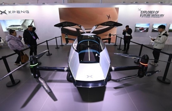 2023年12月1日，在鏈博會智能汽車鏈展區(qū)小鵬汽車展臺，參觀者觀看一臺智能飛行器。新華社記者蔡湘鑫攝