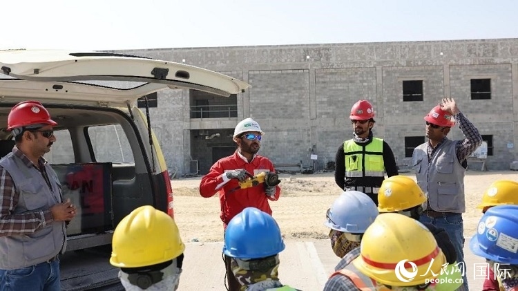 穆薩瓦爾(圖中紅衣人）現(xiàn)場(chǎng)演示工具操作規(guī)范。人民網(wǎng)記者 管克江攝