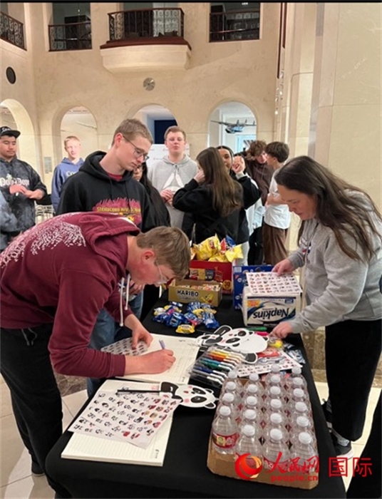 學(xué)生們出發(fā)前紛紛在留言簿留言。人民網(wǎng)記者 鄧圩攝