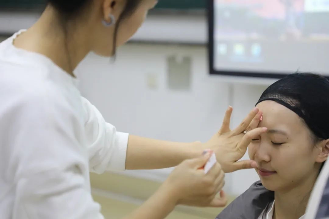 課堂上，一名學(xué)生在體驗(yàn)上戲妝。學(xué)校供圖