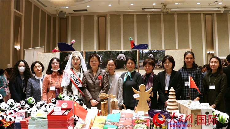 中國駐日本大使吳江浩夫人丁玥（左五）與使館人員在展位前合影留念。人民網(wǎng) 許可攝