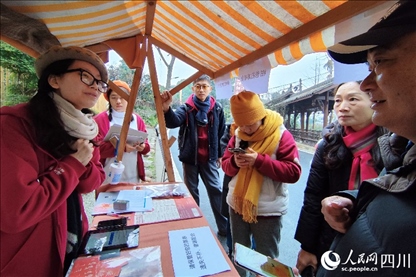 1月6日，“2024成都蒲江柑甜采摘節(jié)”上，記者見到了小萌（左一）和許多年輕人忙著做訪客接待、現(xiàn)場布置、票務(wù)核對、采摘服務(wù)等工作。人民網(wǎng)記者朱虹攝