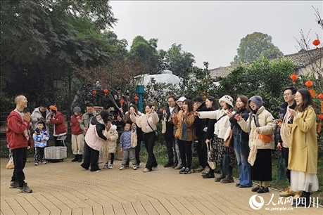 葉科（左一）給前來參與活動的“柑爸柑媽”介紹生態(tài)種植果。人民網(wǎng)記者朱虹攝