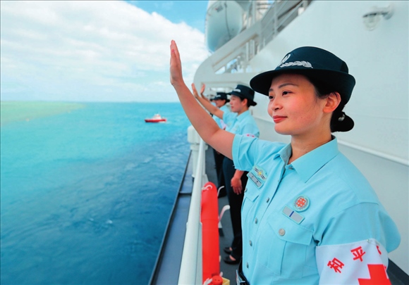 中國海軍“和平方舟”號(hào)醫(yī)院船結(jié)束訪問湯加時(shí)，任務(wù)官兵中的文職人員向歡送人群揮手告別（2023年8月4日攝）。徐巍攝/本刊