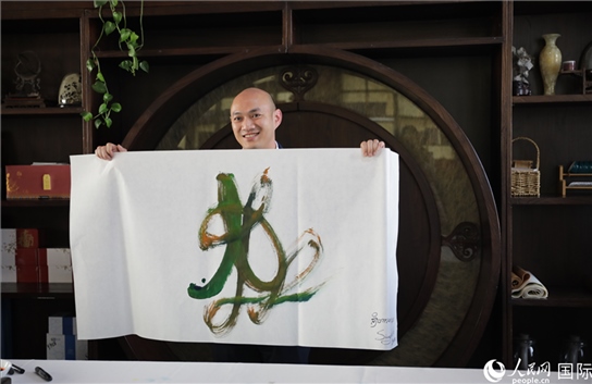 老撾駐華大使館三秘明君參加《五百筆·瀾湄合作》集體藝術(shù)創(chuàng)作。人民網(wǎng)王婧攝。