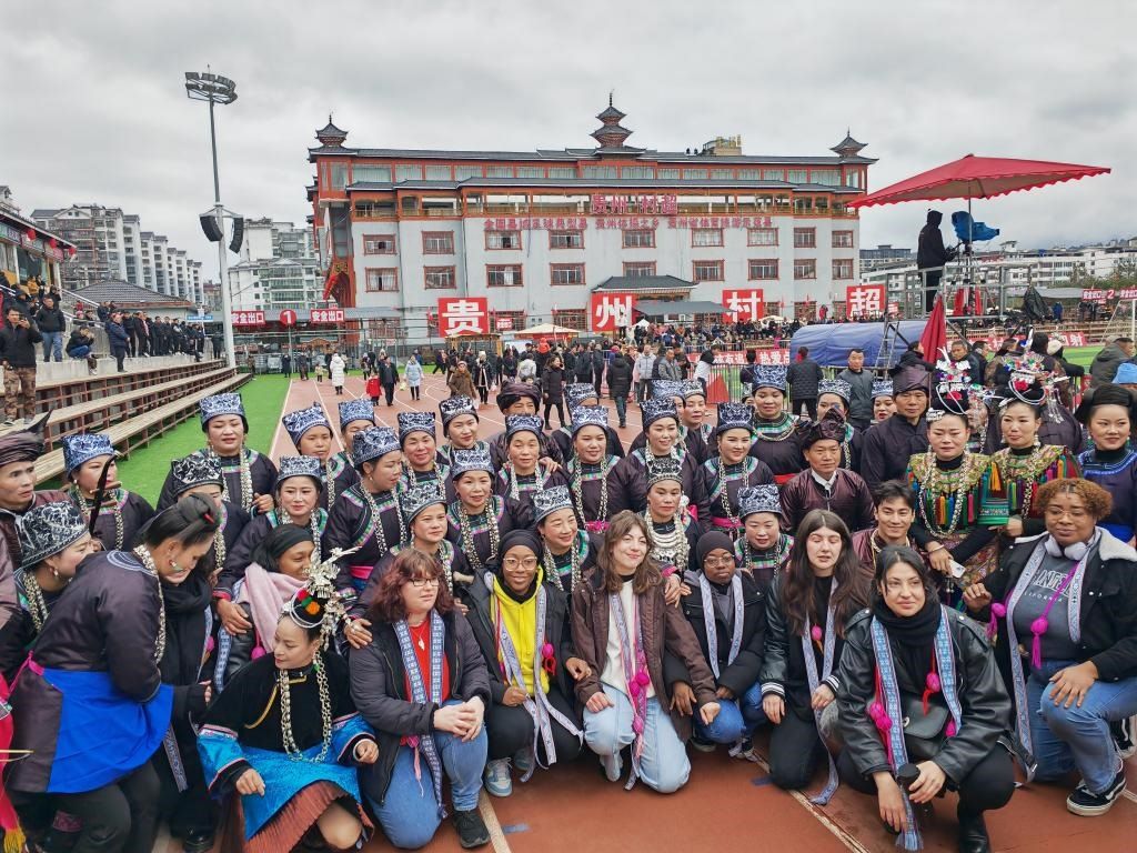 法國青年在“村超”賽場邊與參加表演的村民合影。新華社記者 羅羽 攝