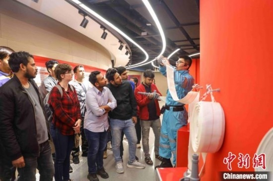 5月9日，工作人員指導(dǎo)留學(xué)生正確使用消防水帶。張鷹 攝