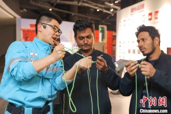 5月9日，工作人員指導(dǎo)留學(xué)生學(xué)習(xí)打繩結(jié)。張鷹 攝