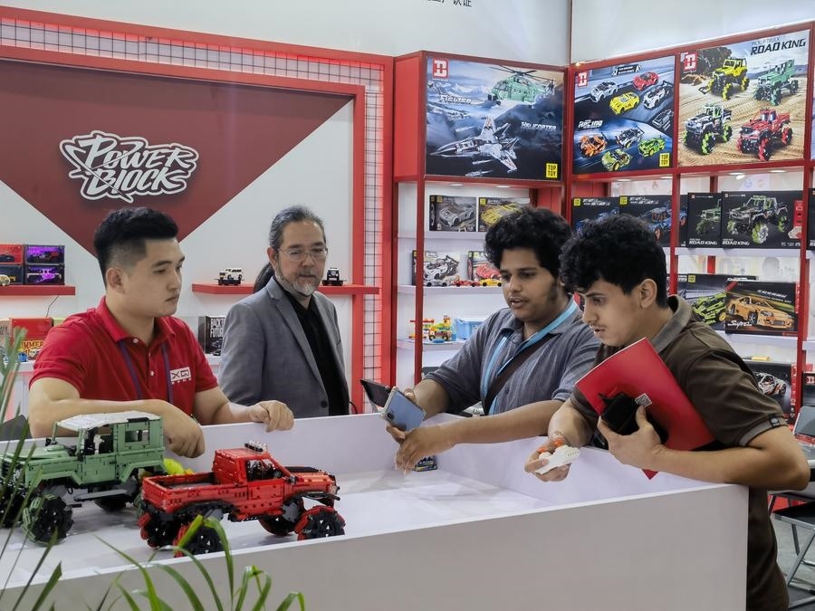 在第135屆廣交會第三期現(xiàn)場，采購商在廣東信宇科技股份有限公司展位選購、體驗(yàn)積木遙控車產(chǎn)品（5月2日攝）。新華社記者 洪澤華 攝