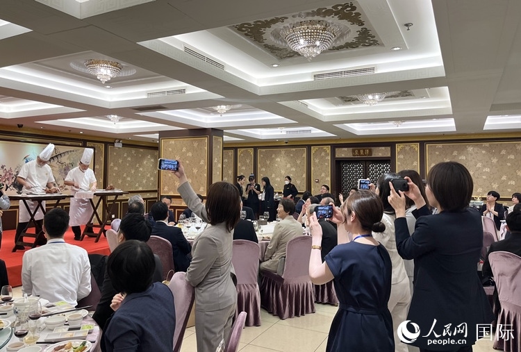 國家級非物質(zhì)文化遺產(chǎn)、全聚德片鴨工藝吸引代表團成員拍照留念。