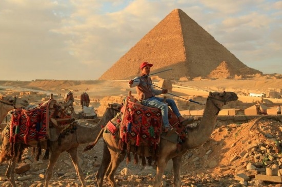1月24日，商販騎駱駝離開埃及吉薩金字塔景區(qū)。新華社記者 隋先凱 攝