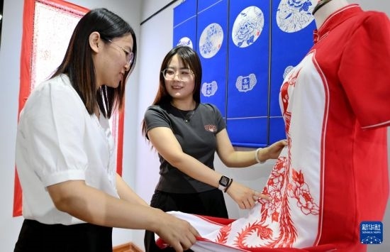 5月31日，在衡水市阜城縣一家剪紙工作室，游客在觀賞帶有剪紙元素的旗袍。