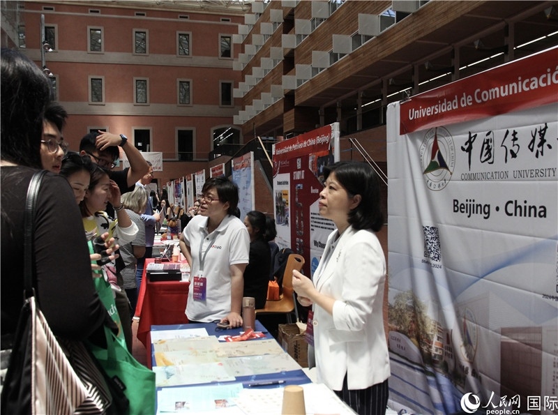 旅西華人華僑在展臺前咨詢。人民網(wǎng)記者 許海林攝