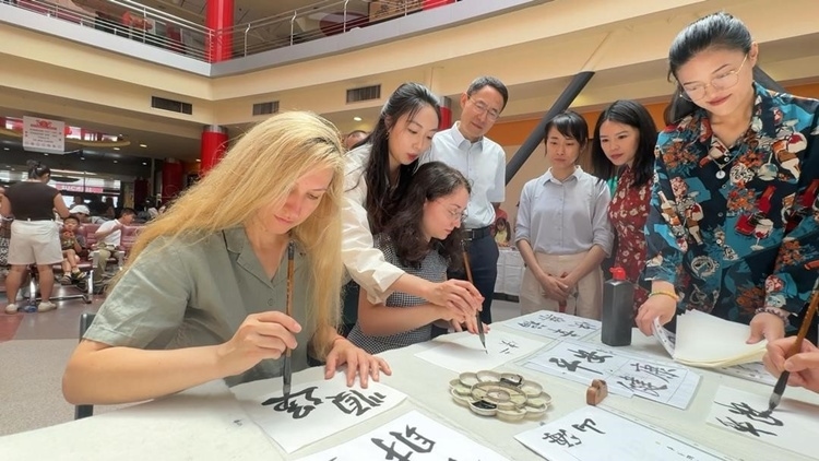 羅馬尼亞友人在活動(dòng)現(xiàn)場(chǎng)學(xué)寫(xiě)漢字。中國(guó)駐羅馬尼亞大使館領(lǐng)僑處供圖