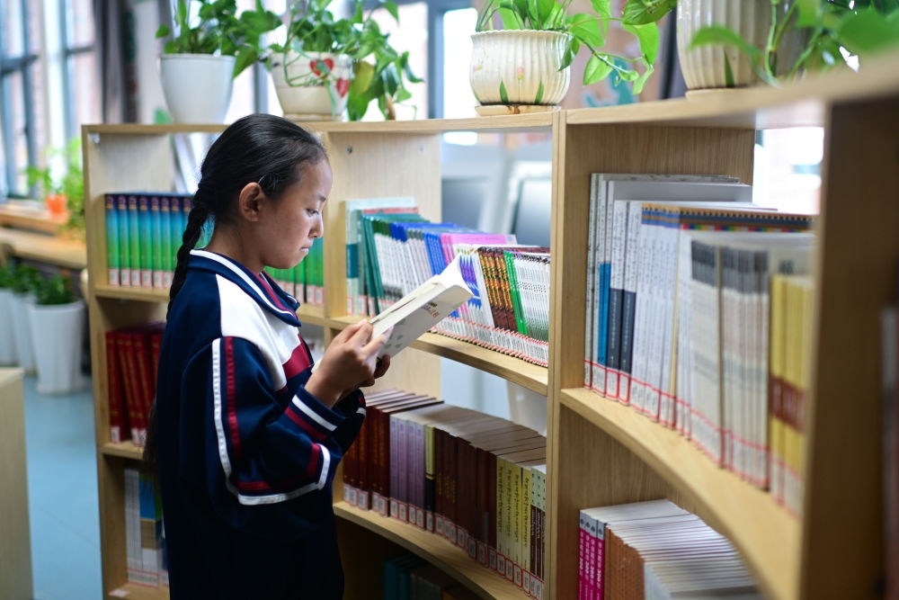 6月18日，果洛西寧民族中學(xué)學(xué)生尼東拉毛在圖書室看書。