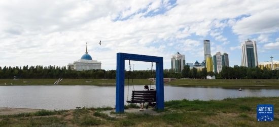 6月30日，一名女子在哈薩克斯坦首都阿斯塔納伊希姆河畔休息。新華社記者 王建華 攝