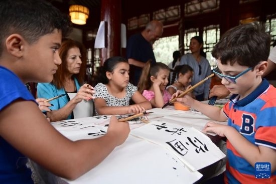 7月4日，在馬耳他桑塔露琪亞市的中國古典園林“靜園”，人們體驗中國書法。新華社發(fā)（喬納森·博格 攝）