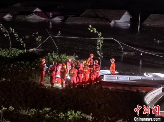  7月6日凌晨3時，在湖南岳陽華容縣團(tuán)洲垸洞庭湖一線堤防，救援人員剛剛完成一次救援任務(wù)，遠(yuǎn)處是被淹的民房。中新社記者 白祖偕 攝