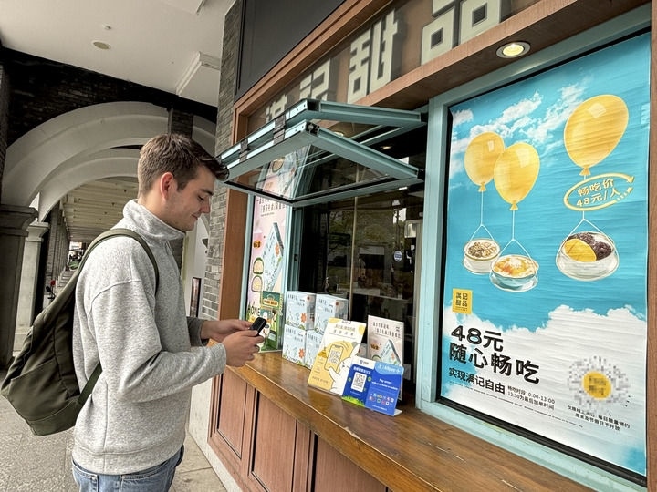 來(lái)自德國(guó)的留學(xué)生理查德在杭州西湖邊一家商鋪使用支付寶掃碼支付（2024年4月11日攝）。新華社發(fā)