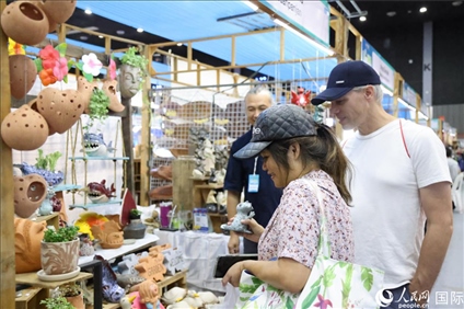 游客在蘭納博覽會(huì)特色展位上選購工藝品。人民網(wǎng)記者楊一攝