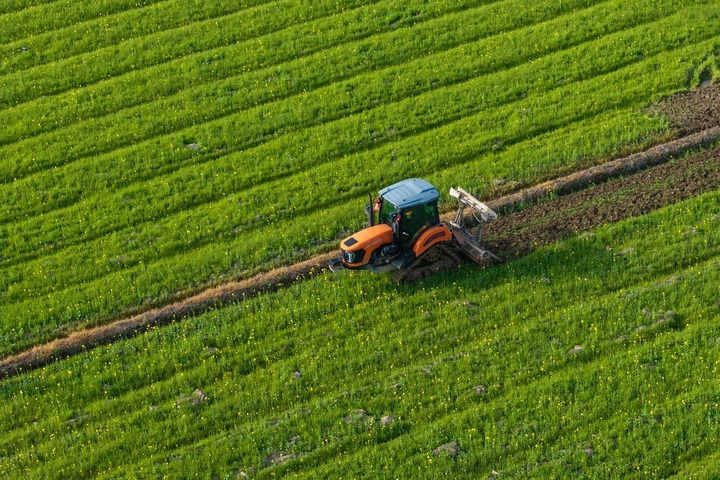 2024年3月19日，在湖南省常德市鼎城區(qū)謝家鋪鎮(zhèn)港中坪村，村民駕駛農(nóng)機翻耕田地（無人機照片）。新華社記者 陳思汗 攝