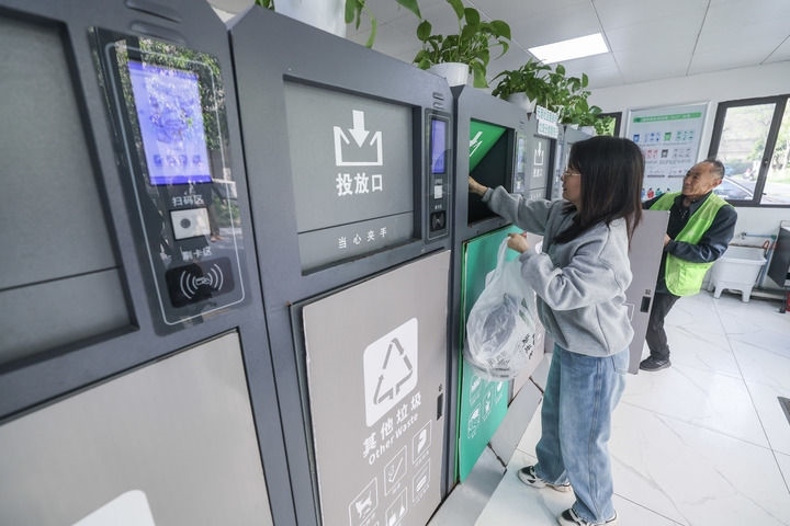 2024年4月10日，在浙江省湖州市吳興區(qū)飛英街道新華府小區(qū)內(nèi)，居民在垃圾分類智能系統(tǒng)的指導下進行垃圾分類投放，居民的投放情況將實時匯總到智慧服務平臺，會有相應的積分獎勵。新華社記者 徐昱 攝