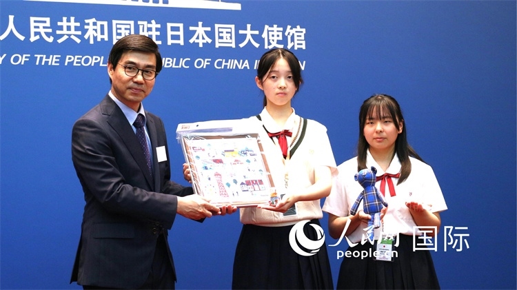 日本小大使向中國駐日本大使館臨時代辦施泳贈送當?shù)靥厣Y品。人民網(wǎng) 許可攝