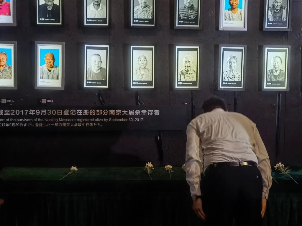 7月18日，人們向離世的南京大屠殺幸存者獻(xiàn)花、鞠躬。新華社記者邱冰清 攝