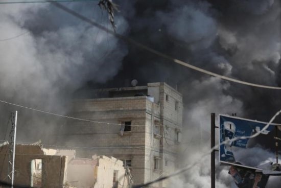 7月21日，在加沙地帶中部的努賽賴特難民營(yíng)，遭以軍空襲的建筑冒出滾滾濃煙。新華社發(fā)（馬爾萬·達(dá)烏德攝）