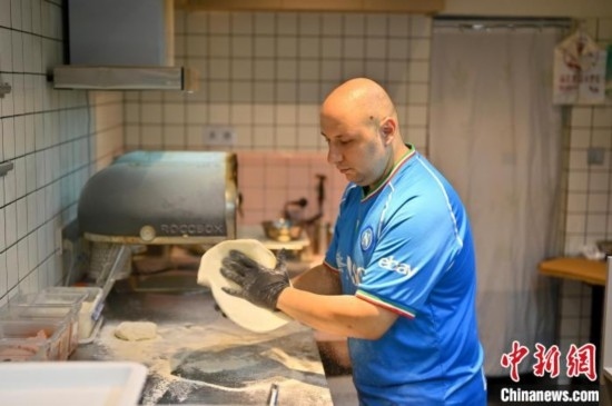 近日，韋榮耀在自家披薩小店內(nèi)忙活。俞靖 攝