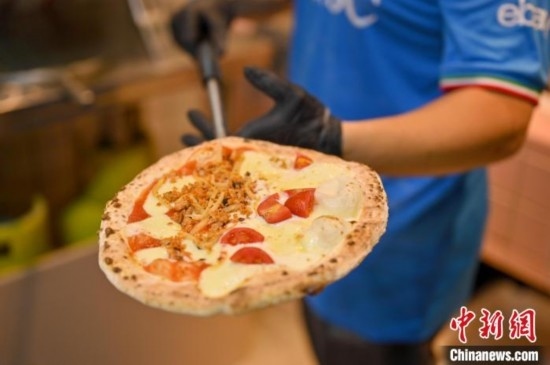 近日，韋榮耀展示他制作的“老友味”披薩。 俞靖 攝