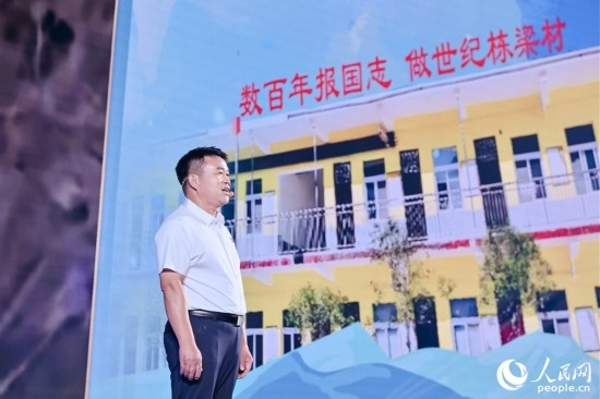 張玉滾分享用一根扁擔(dān)送孩子們走出大山的故事。人民網(wǎng)攝